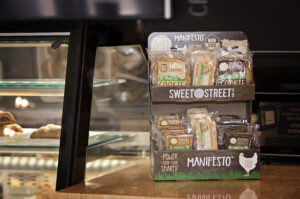 Sweet Street Manifesto Desserts Cardboard Display on Bakery Counter.
