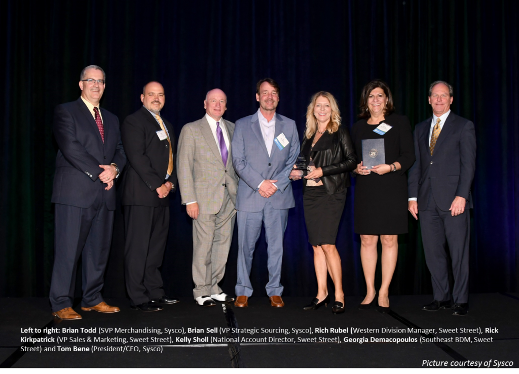 Image of Sysco Leaders and Sweet Street Staff, on stage at awards ceremony. 